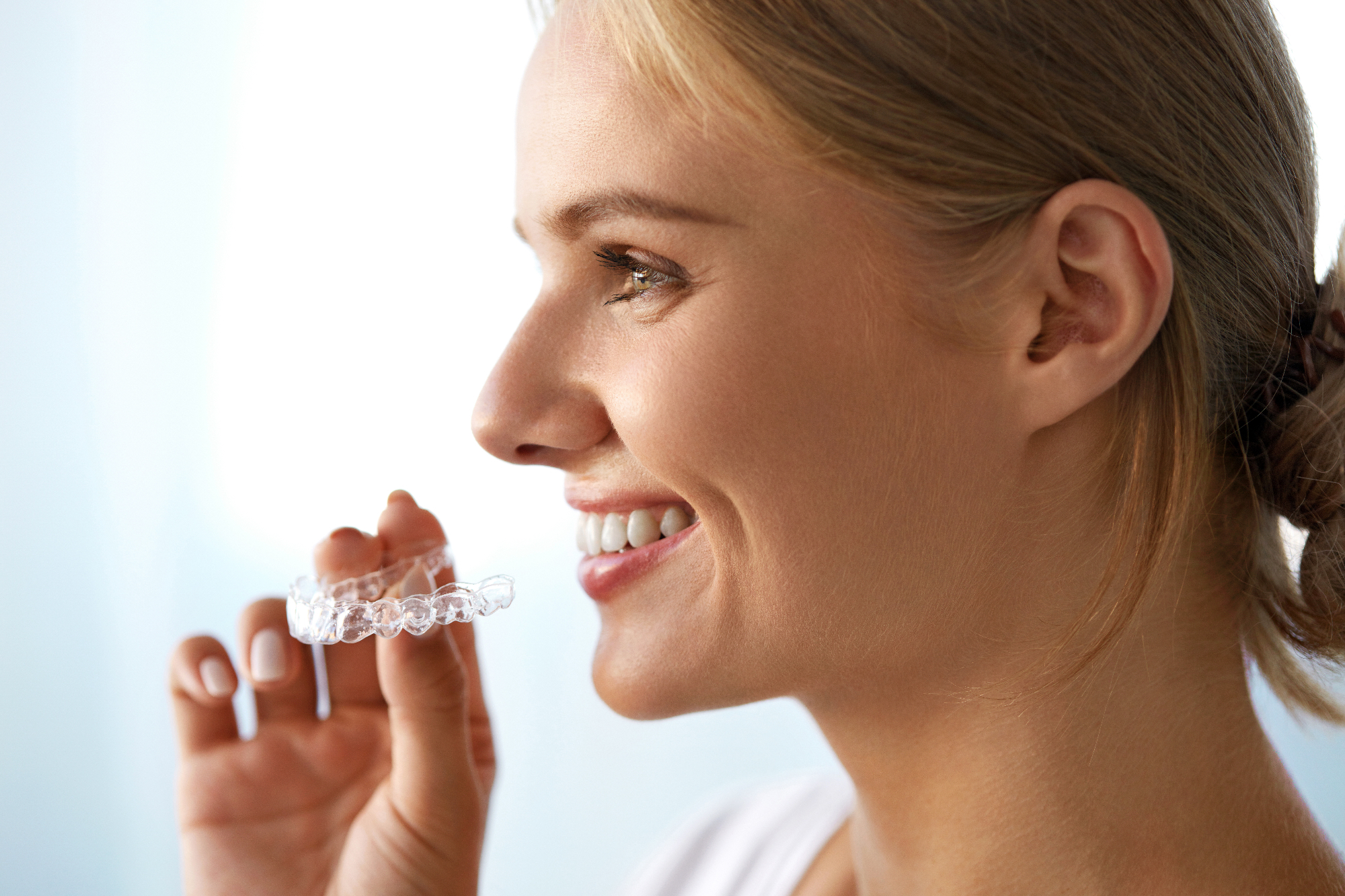 Jabolko in zobni aparat Invisalign gresta z roko v roki